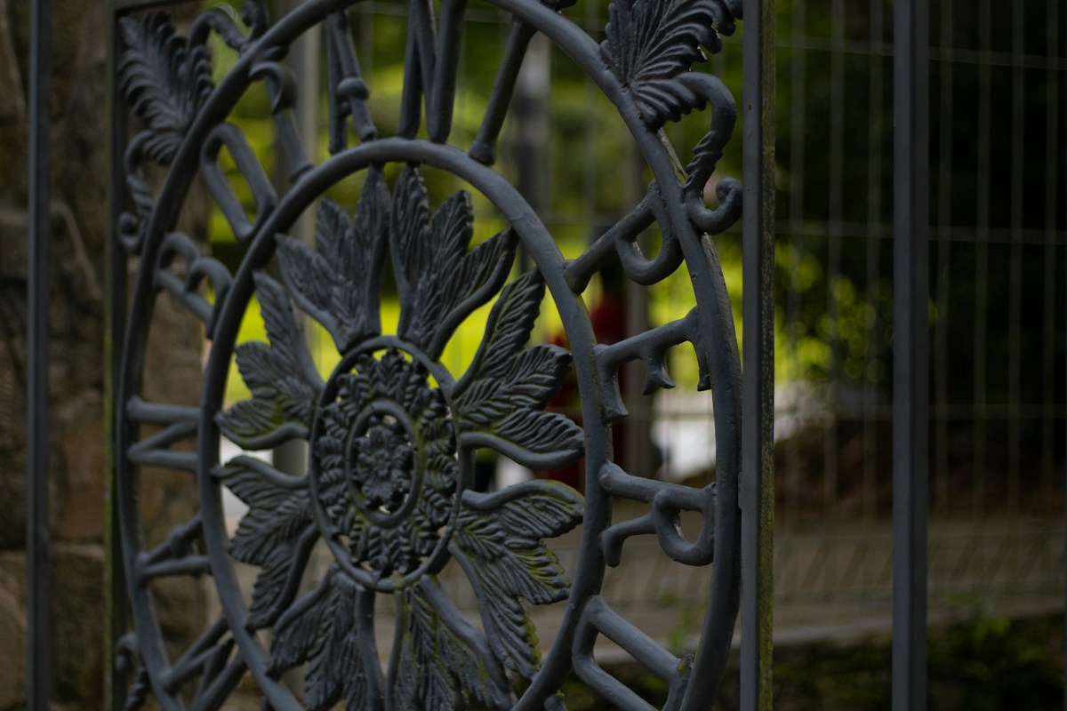 Détail d’une grille en fer forgé ornée de feuilles.