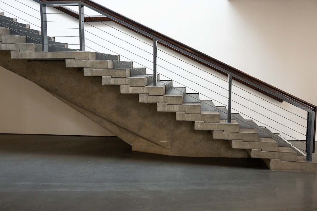Escalier en béton avec rampe métallique.