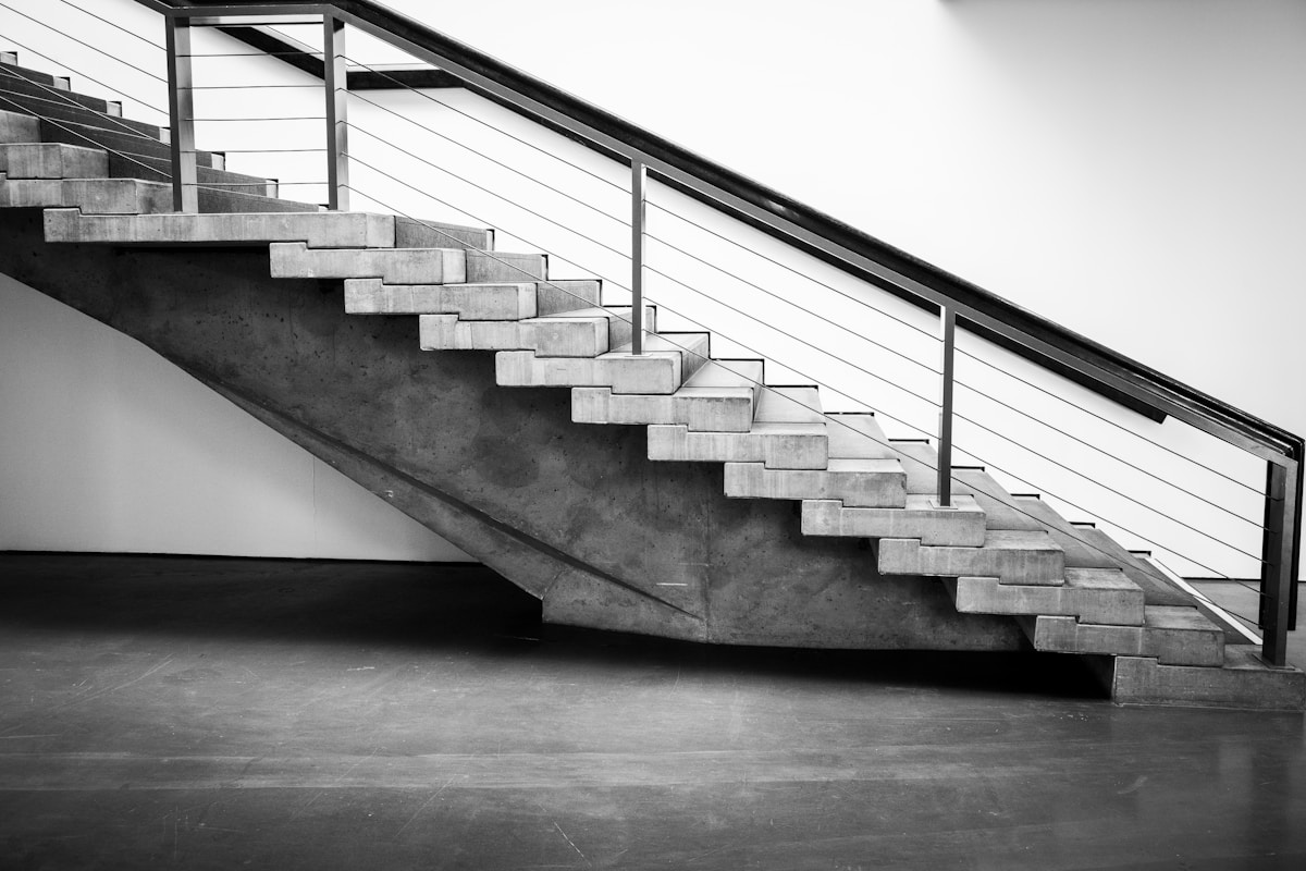 Escalier en béton moderne avec rampe métallique.