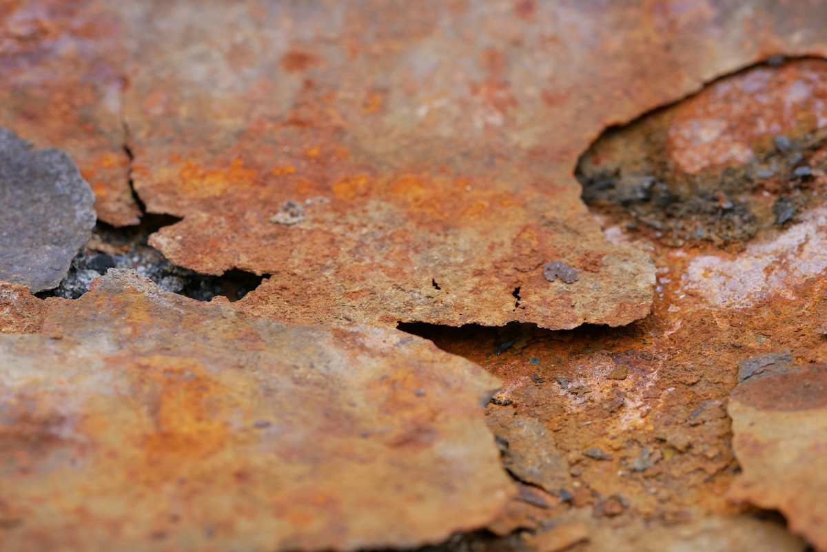 Texture rocheuse rouillée avec des fissures et des nuances orangées.