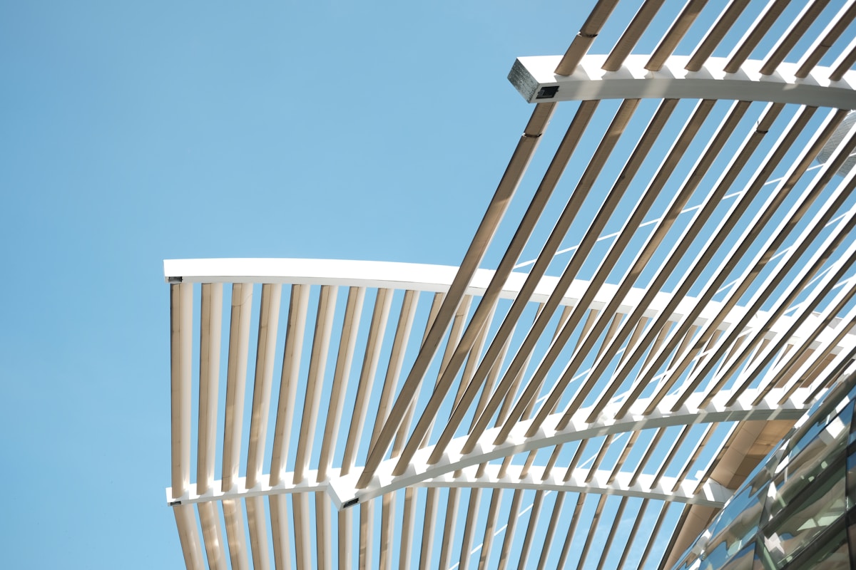 Structure architecturale en bois et métal contre un ciel bleu.