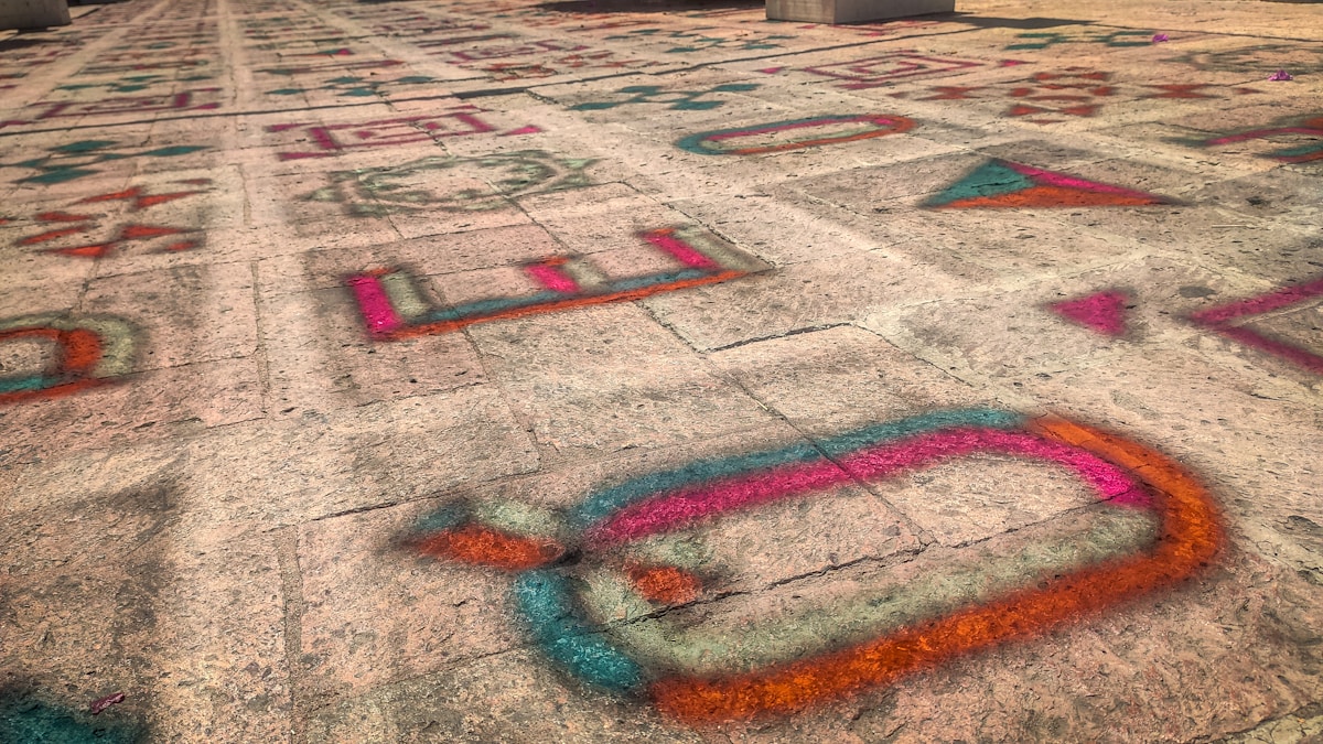 Motifs géométriques colorés sur un sol en béton.