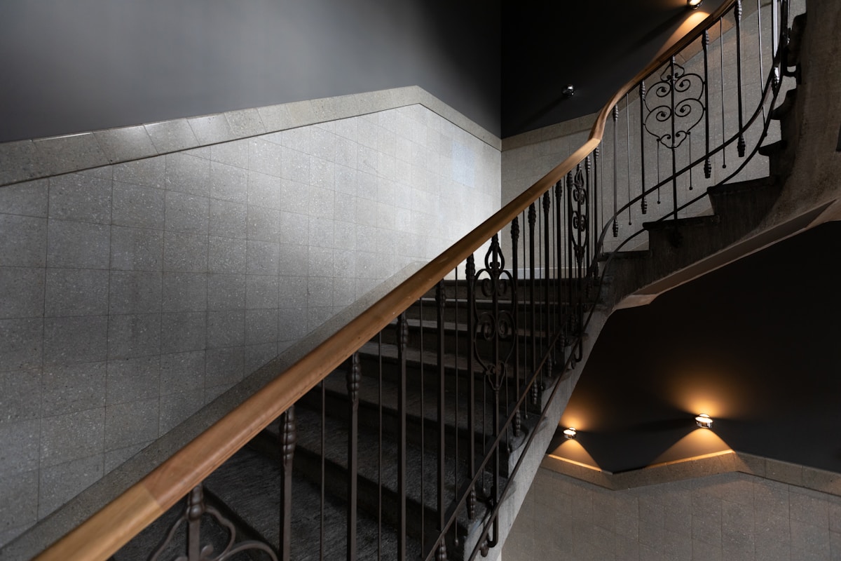 Escalier en colimaçon avec rampe en métal ouvragé.