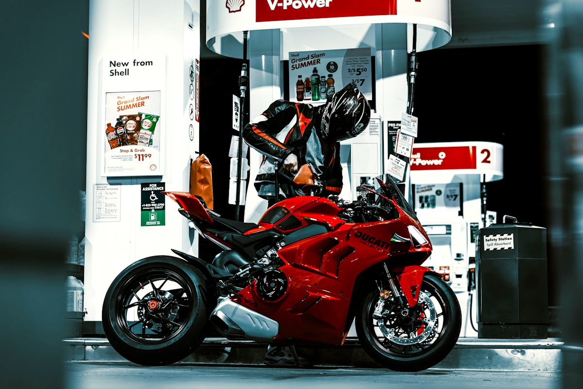 Moto de sport rouge Ducati garée dans une station-service.