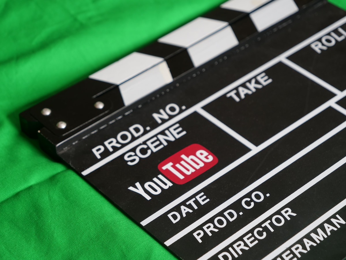 Clap de cinéma avec le logo YouTube sur fond vert.