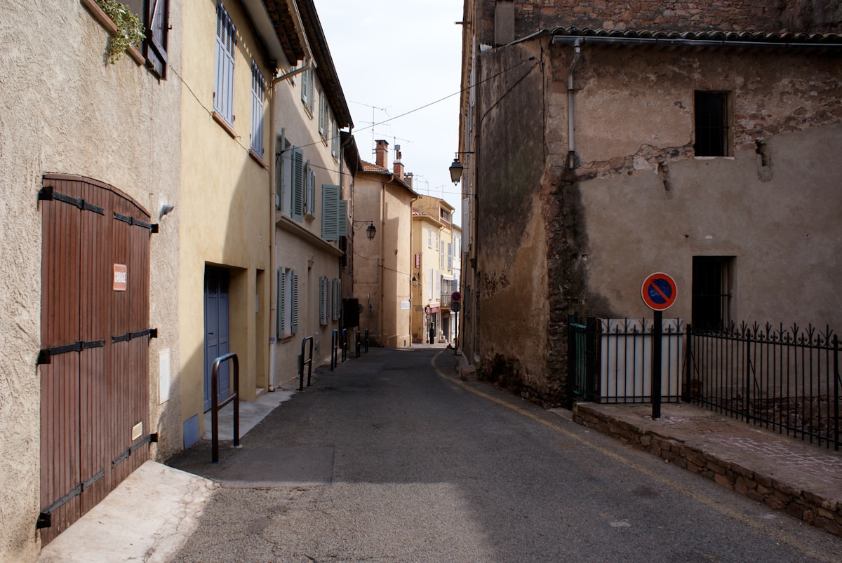 Ruelle étroite avec bâtiments anciens et portes en bois.