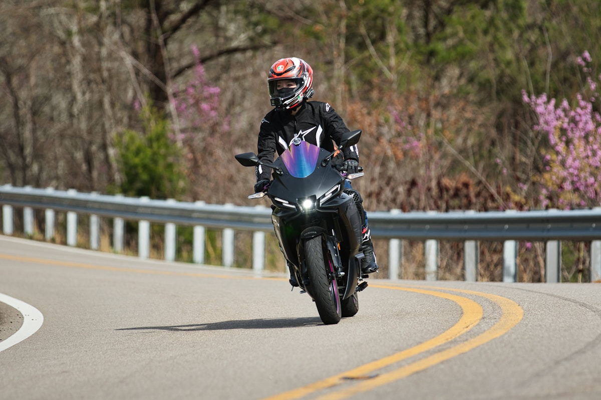 Motocycliste en tenue de protection roulant sur une route sinueuse.