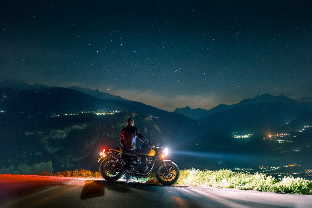 prix location moto suisse - man siting on motorcycle at night