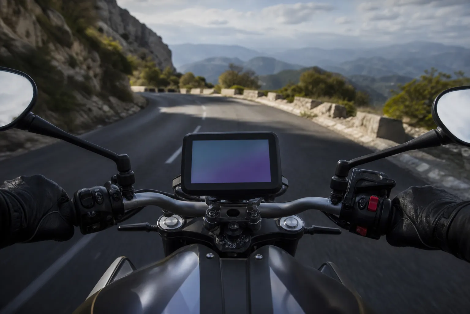 Moto sur une route de montagne avec un écran de navigation.
