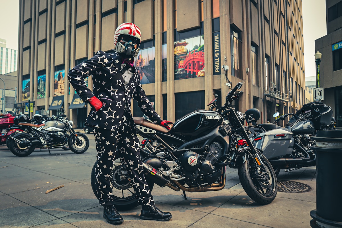Motard en combinaison étoilée sur une moto Yamaha noire dans une rue urbaine.