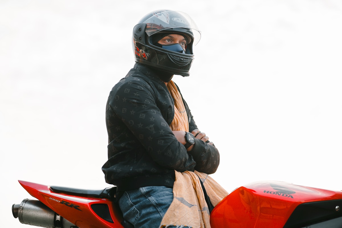 Motocycliste en tenue de protection sur une moto rouge.