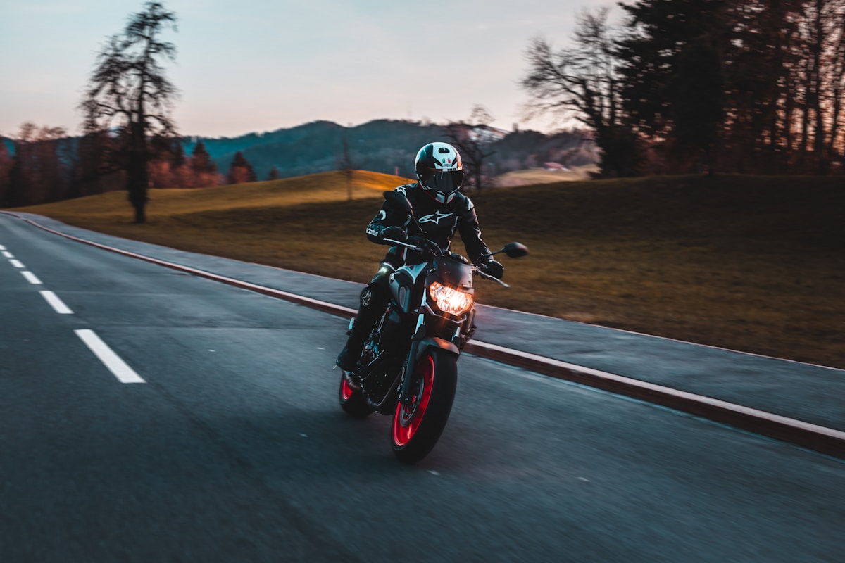 Motocycliste sur une route de campagne au coucher de soleil.