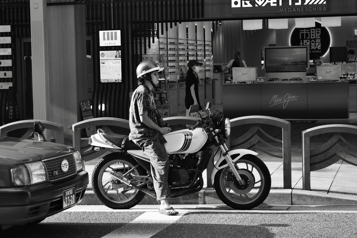 Homme sur une moto blanche dans un environnement urbain.