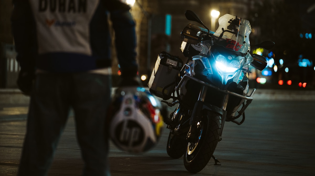 Moto de sport bleue garée dans une rue la nuit.
