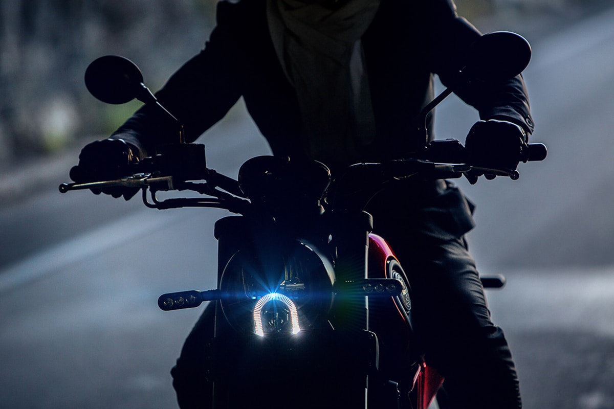 Moto de sport moderne avec phare lumineux dans l'obscurité.