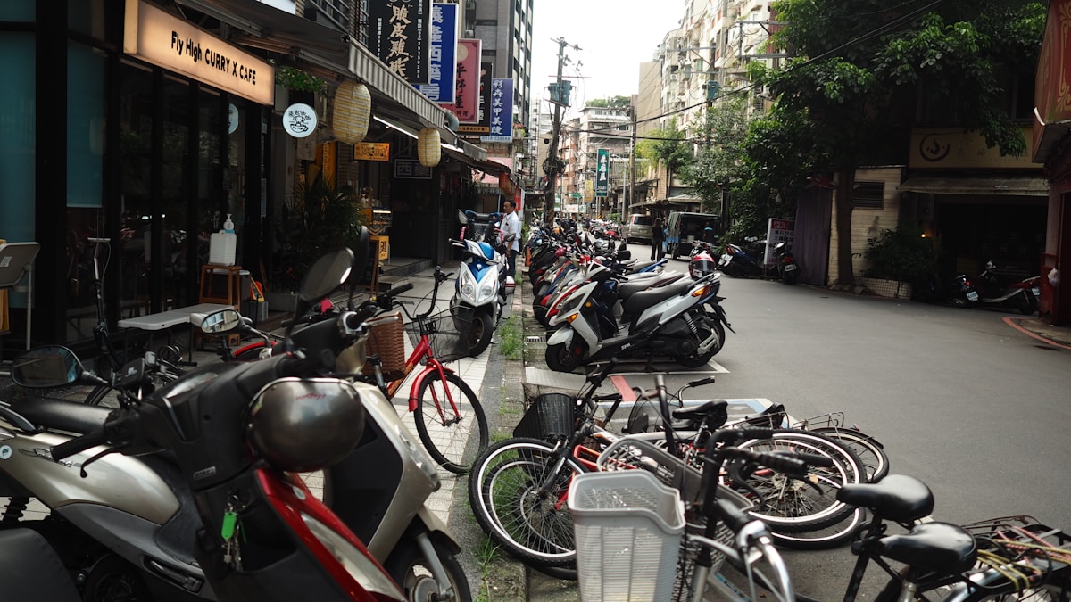Rue animée avec de nombreux scooters et vélos garés.