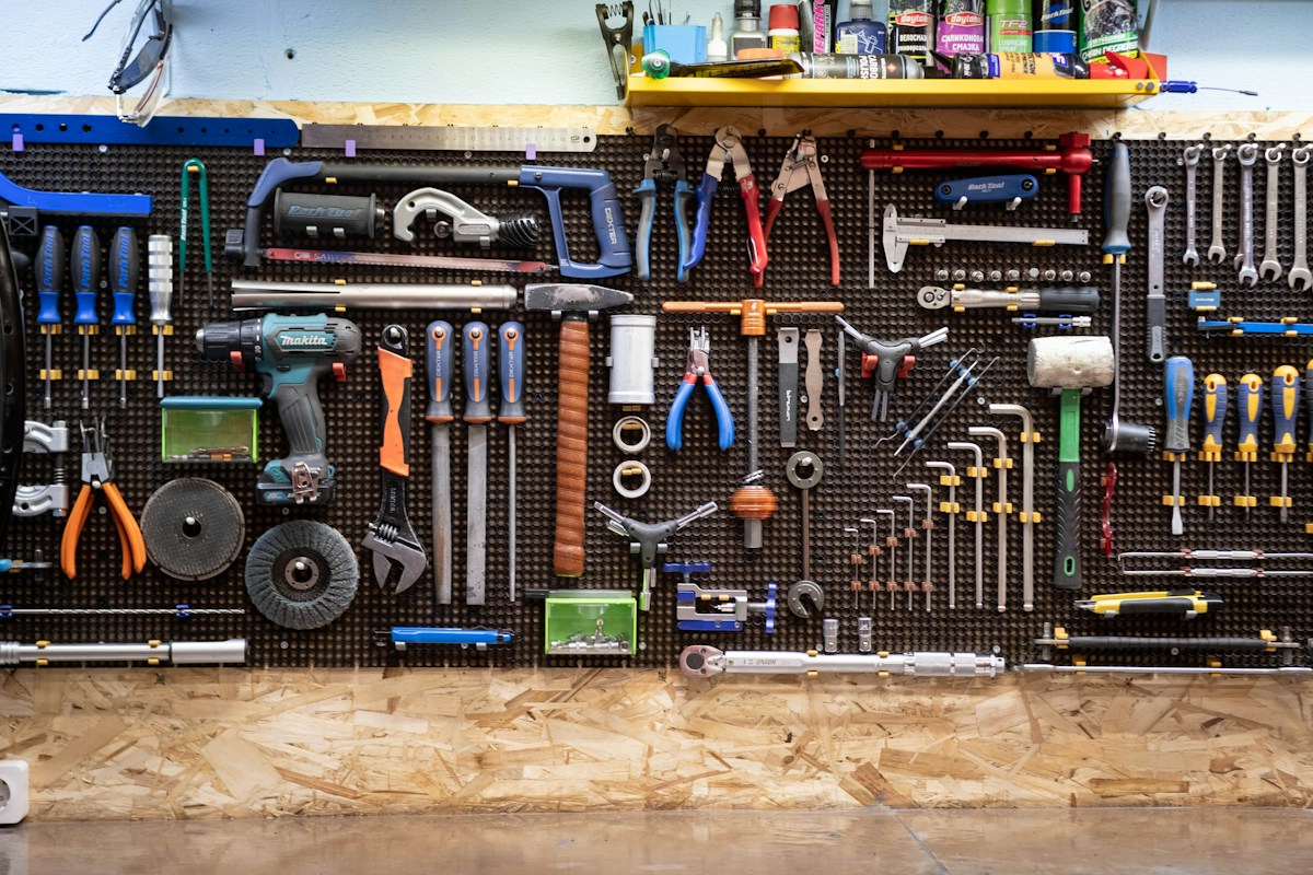 Mur d’atelier soigneusement organisé avec nombreux outils et lubrifiants