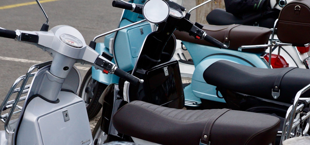 Scooter électrique bleu turquoise avec selle en cuir brun.