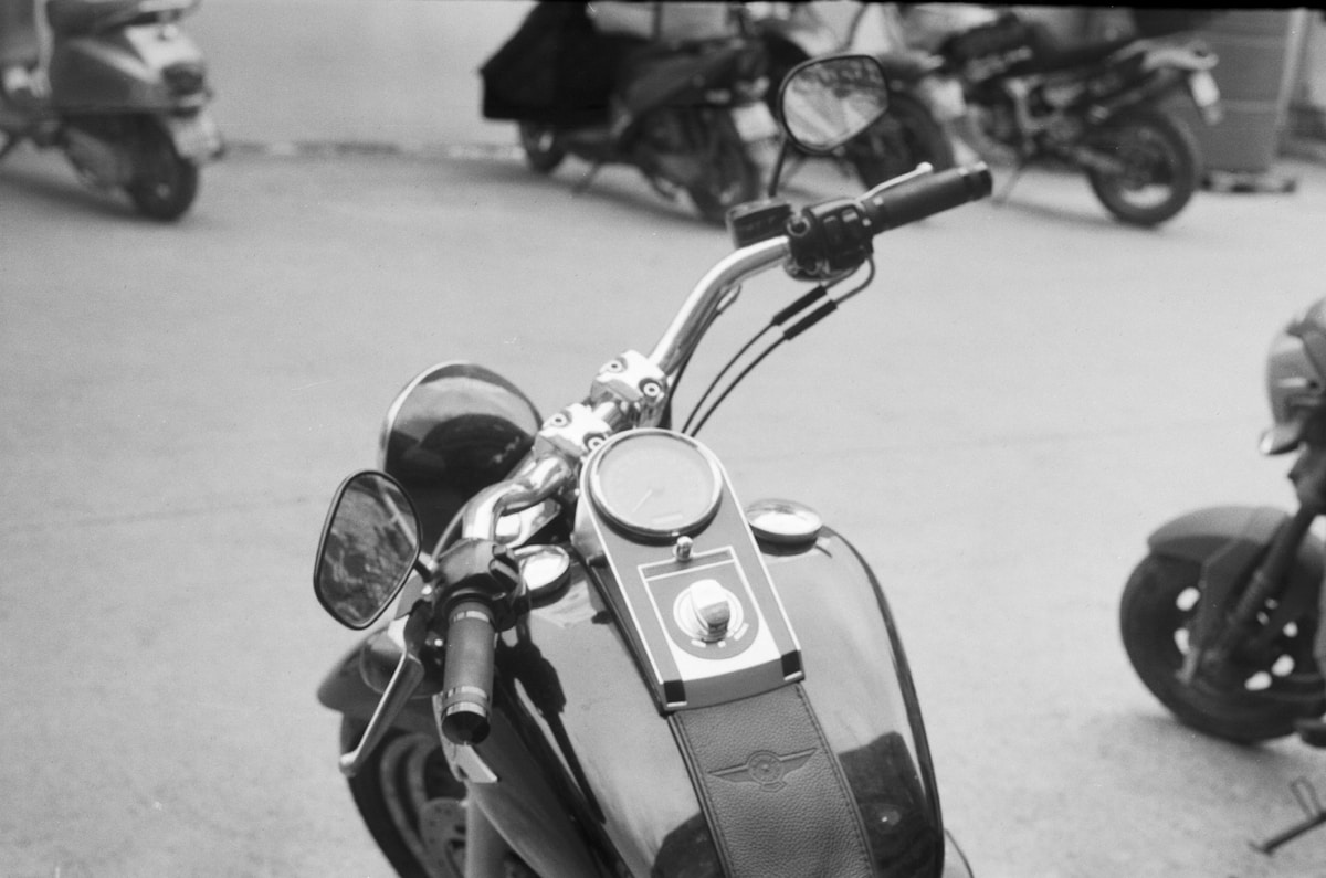 Gros plan sur le guidon d'une moto vintage en noir et blanc.