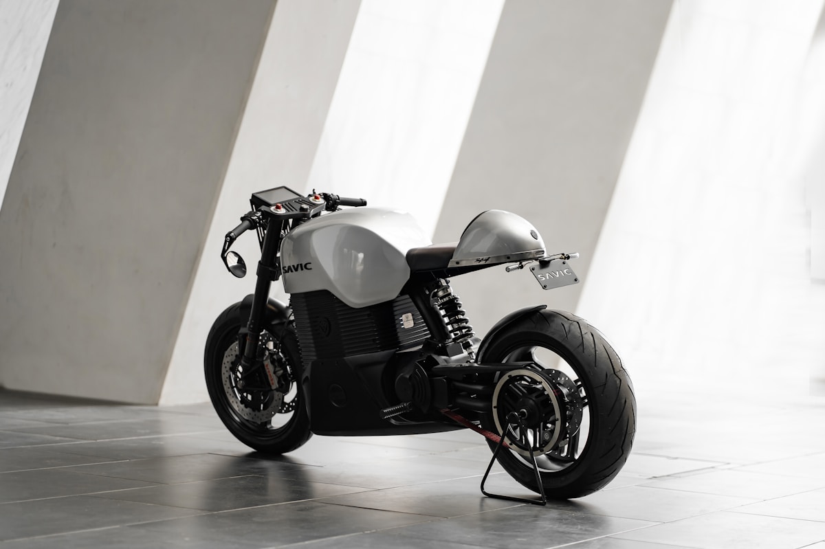 Moto café racer noire et grise avec détails aérodynamiques.