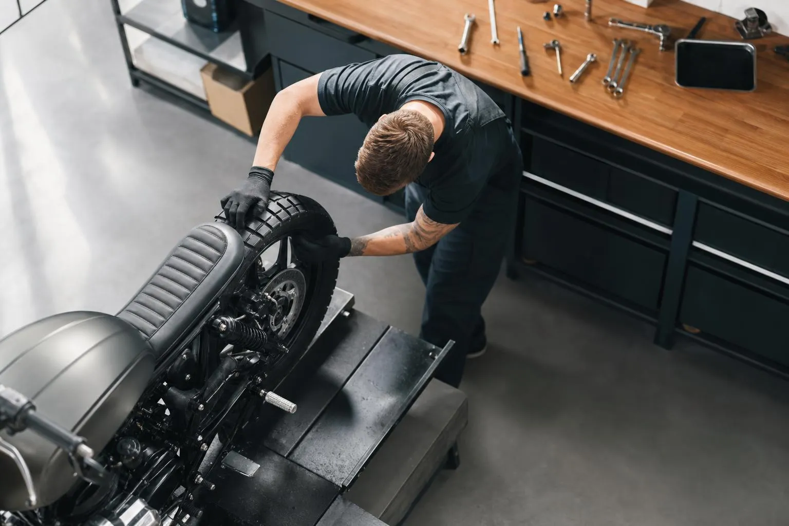 Mécanicien réparant une moto dans un atelier.