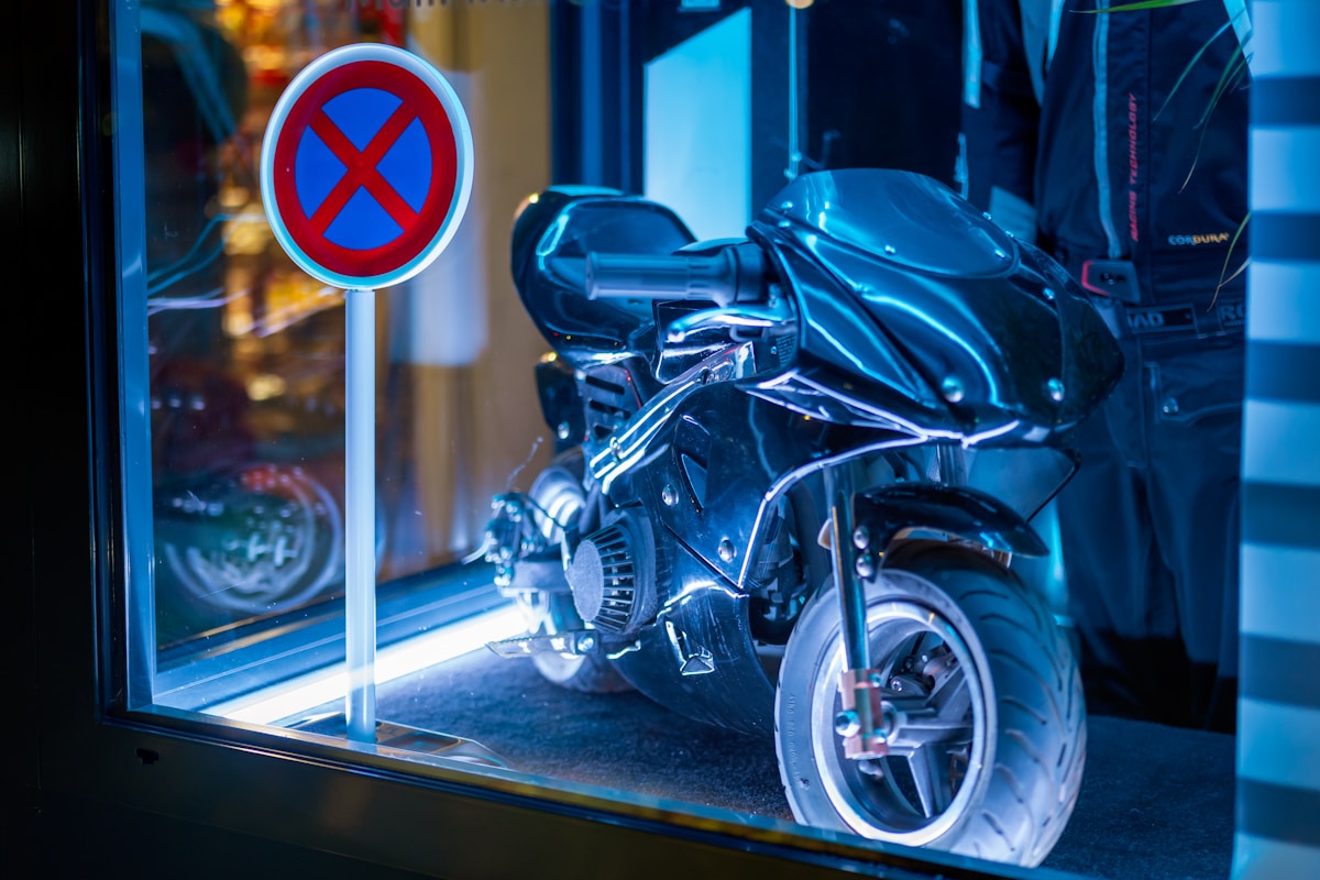 Moto noire garée devant un panneau d'interdiction de stationnement.