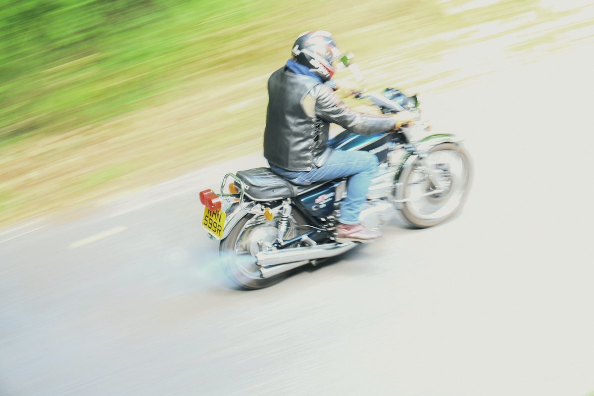 Motocycliste en mouvement rapide sur une route floue.