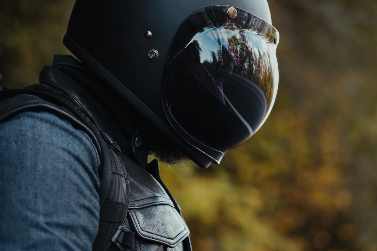 Casque de moto noir avec reflet du paysage.
