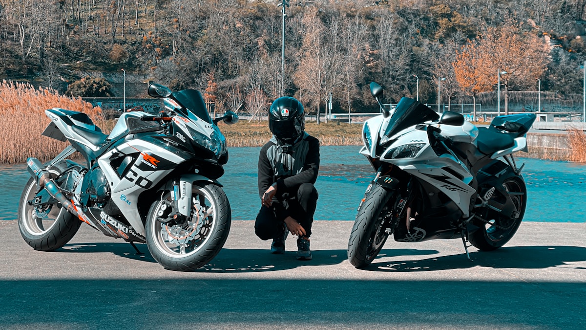 Deux motos sportives Suzuki de couleur verte et blanche, avec un motard en tenue noire.