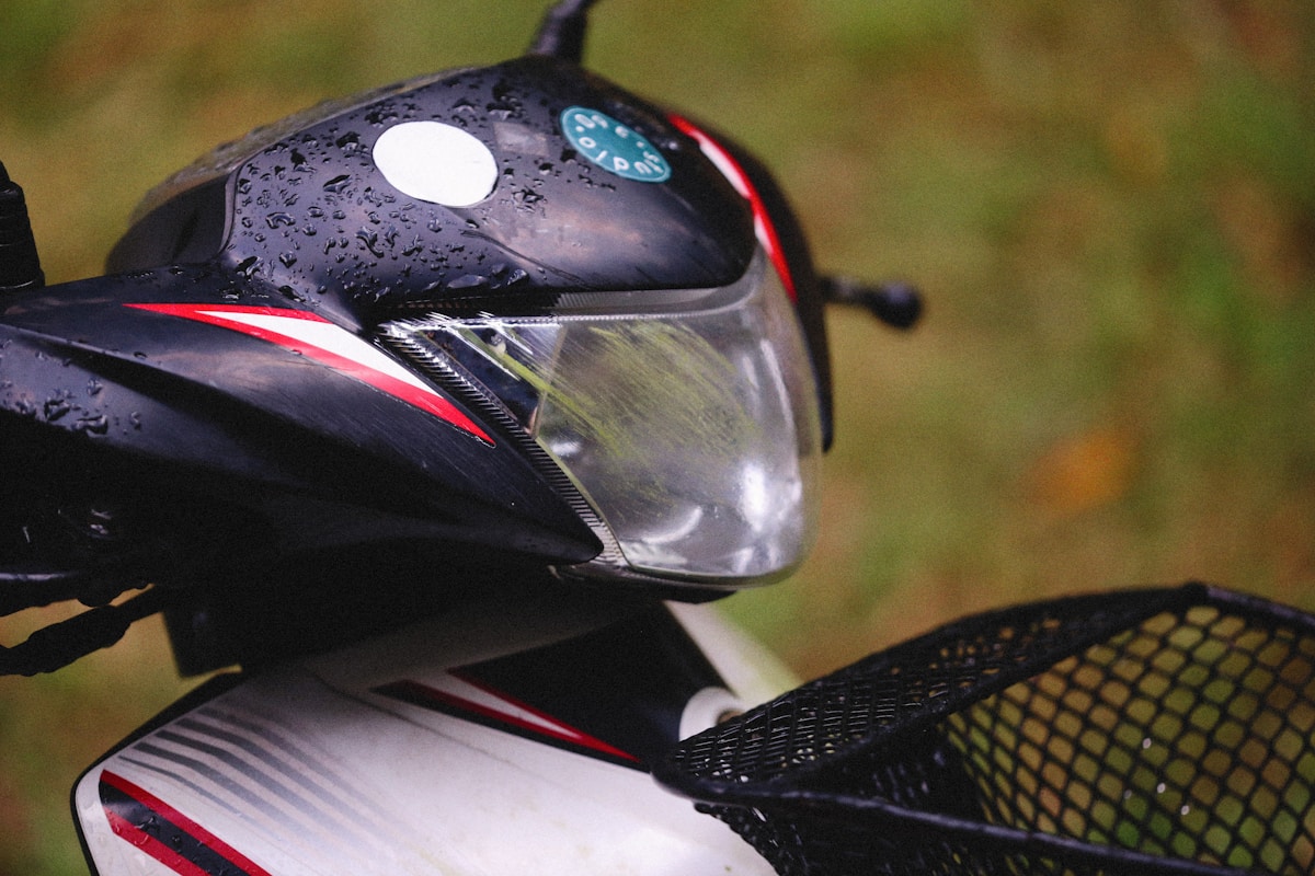 Casque de moto noir avec détails rouges et visière transparente.