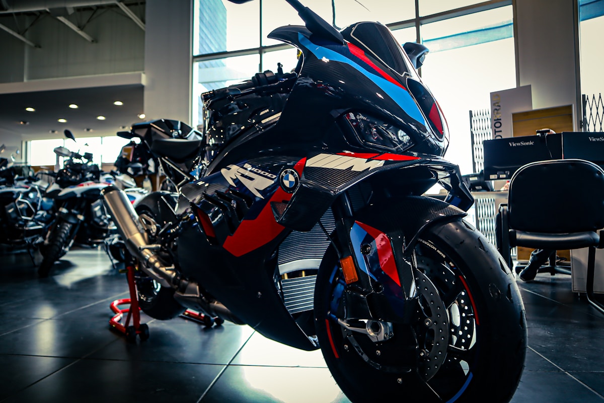 Moto sportive BMW noire, rouge et bleue dans un showroom.