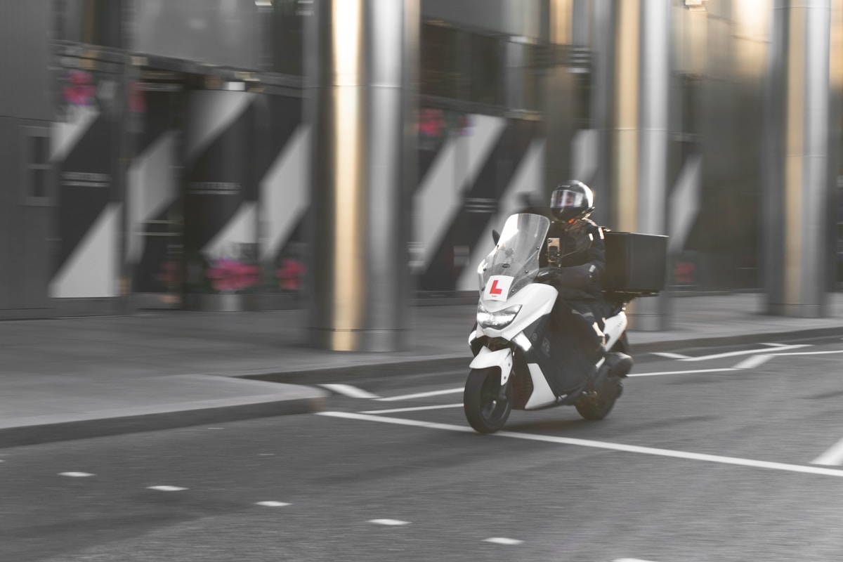 Motard sur un scooter en mouvement dans une ville.