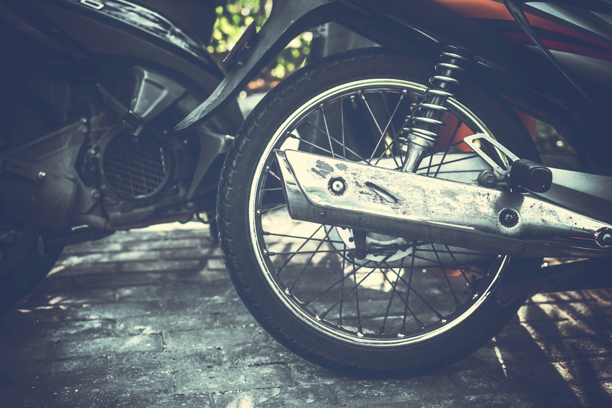 Roue de moto vintage avec suspension et pneu sale.