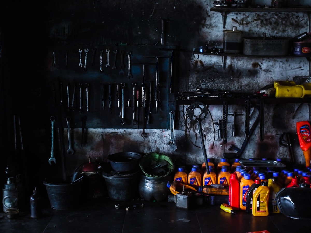 Atelier sombre rempli d'outils et de fournitures mécaniques.