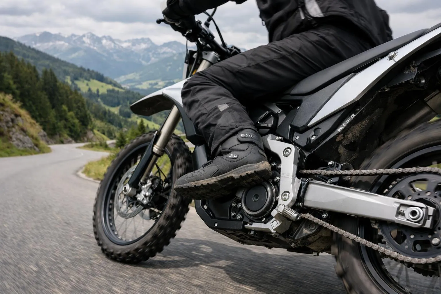 Moto tout-terrain sur une route de montagne avec paysage verdoyant.