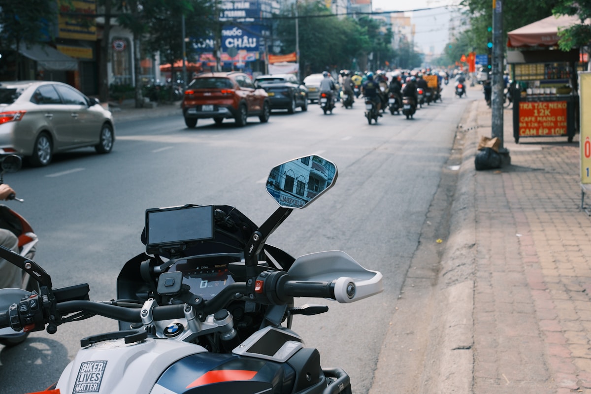 Scène animée d'une rue urbaine avec motos, voitures et piétons.