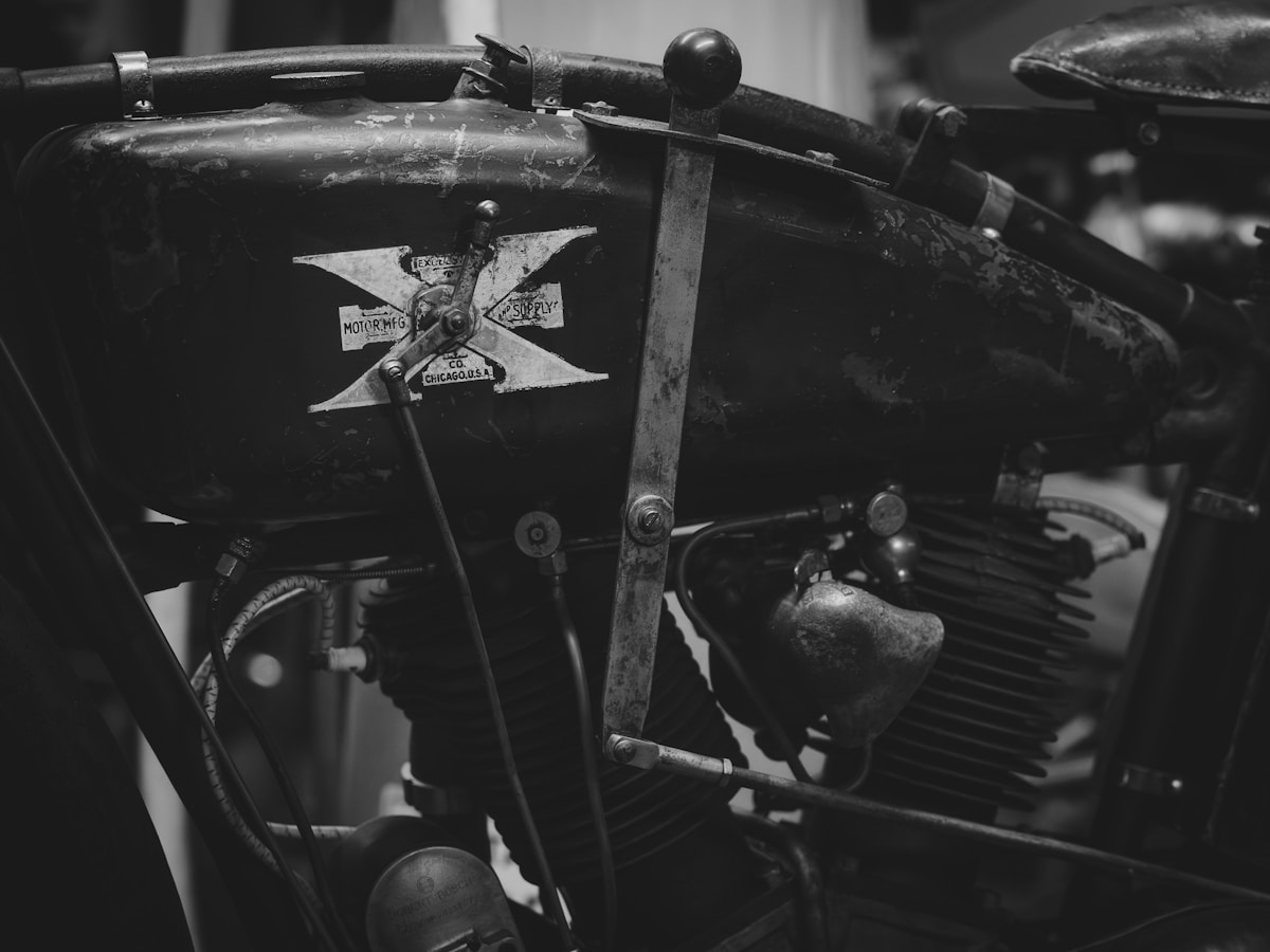 Vieux moteur de moto en noir et blanc, détails rouillés et usagés.