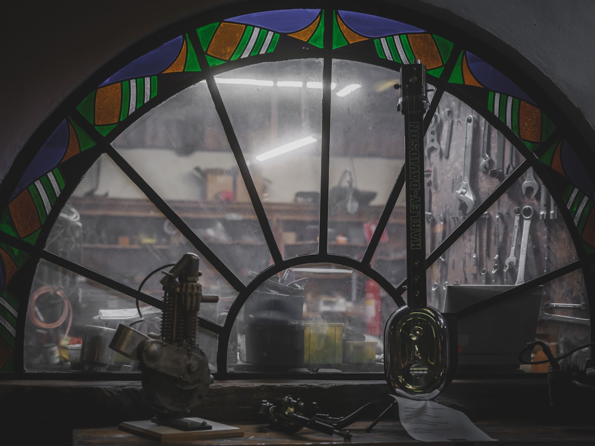 Atelier de réparation automobile avec outils et fenêtre en verre teinté.