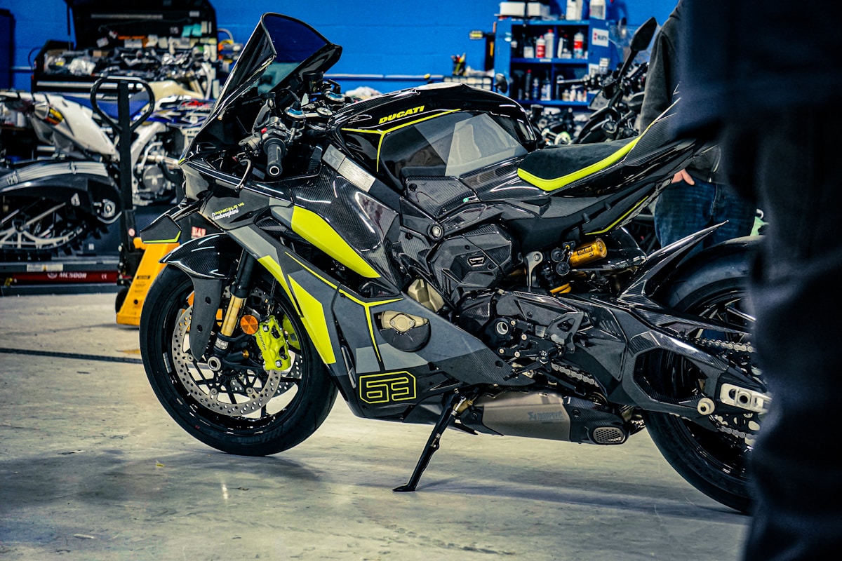 Moto Ducati noire et jaune dans un atelier de réparation.