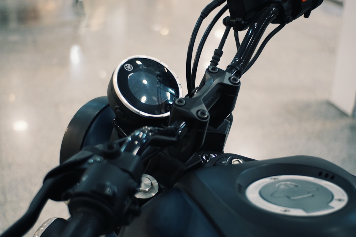 Gros plan sur le tableau de bord d'une moto noire avec des détails en métal.