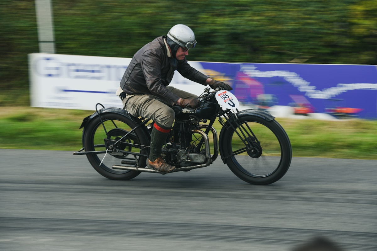 Motocycliste en casque roulant rapidement sur une piste.