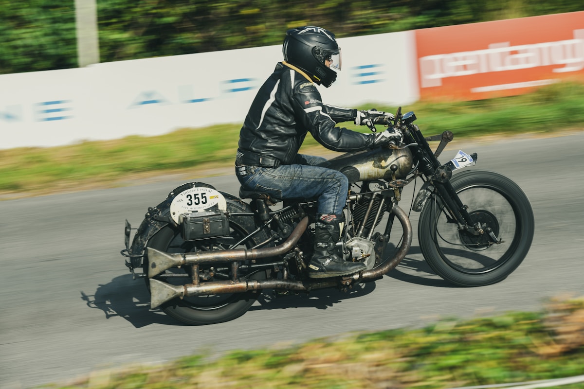Motard sur une moto de course vintage en pleine vitesse sur la piste.