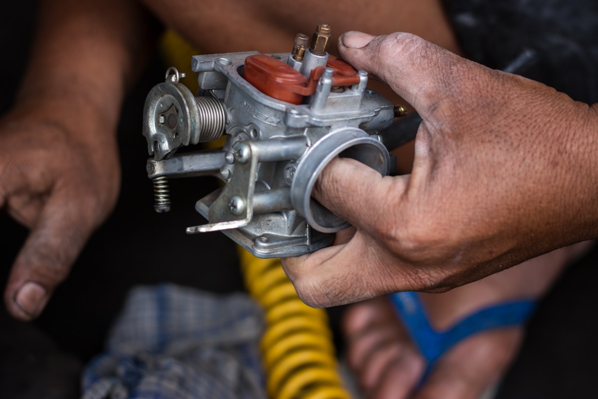 Mécanicien réparant le carburateur d'un moteur.