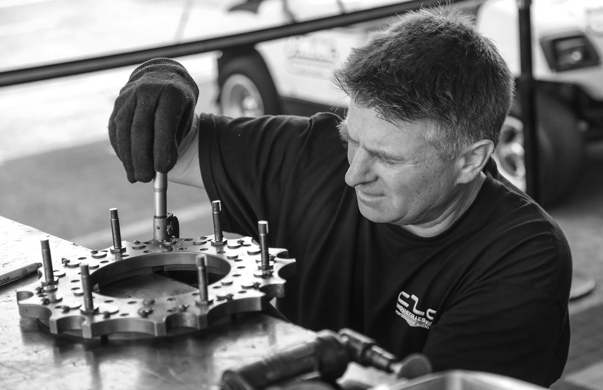 Homme travaillant sur un mécanisme complexe dans un atelier.