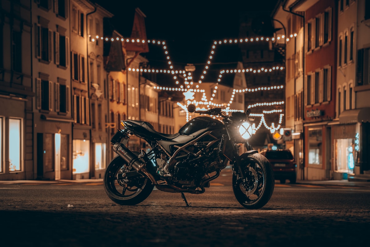 Moto noire sur une rue illuminée la nuit.
