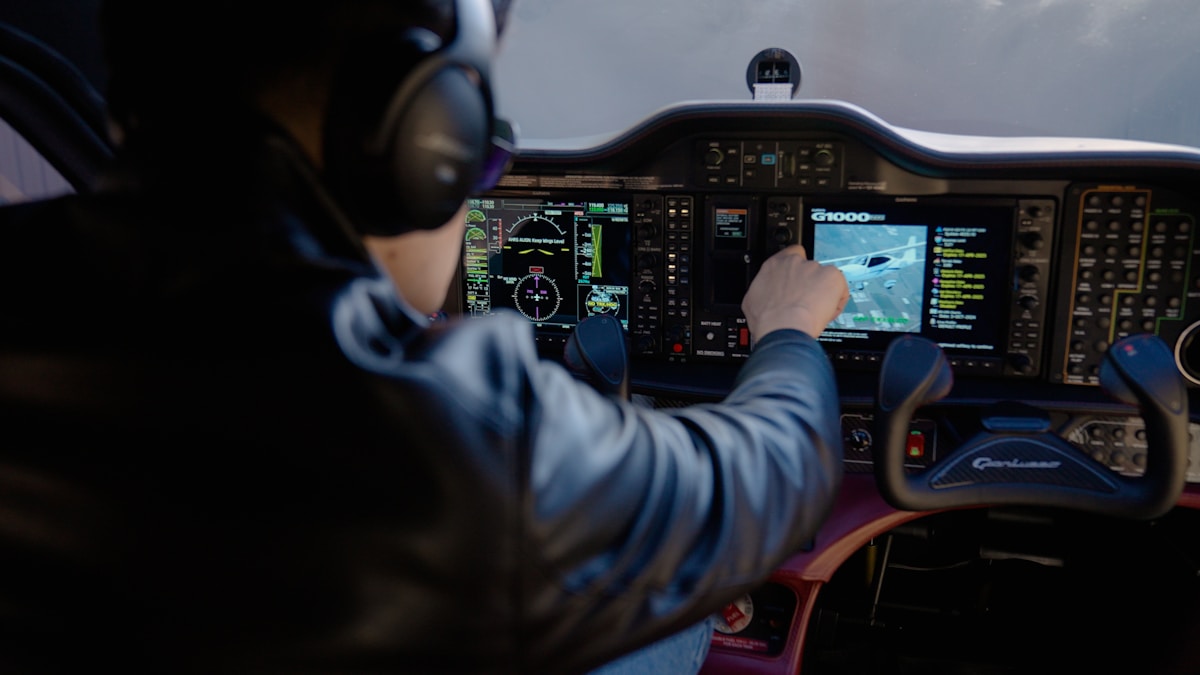 Tableau de bord d'un cockpit d'avion avec de nombreux écrans et commandes.