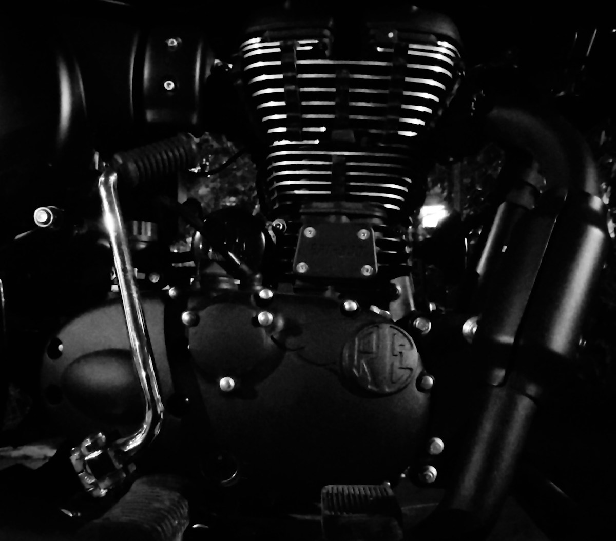 Moteur de moto noir et blanc avec détails mécaniques.