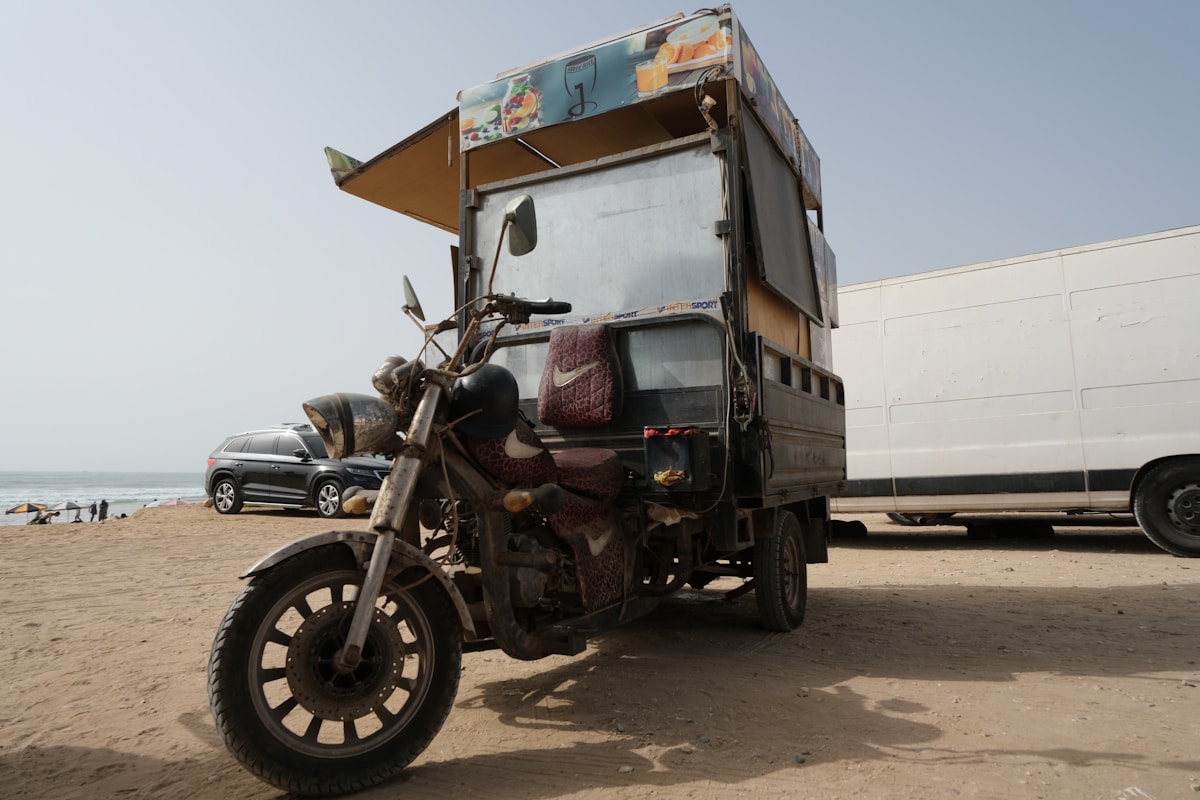 Camion de livraison avec moto sur la plage.