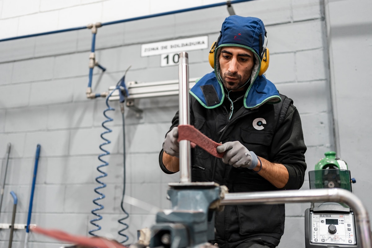 Ouvrier industriel en équipement de sécurité travaillant dans un atelier.