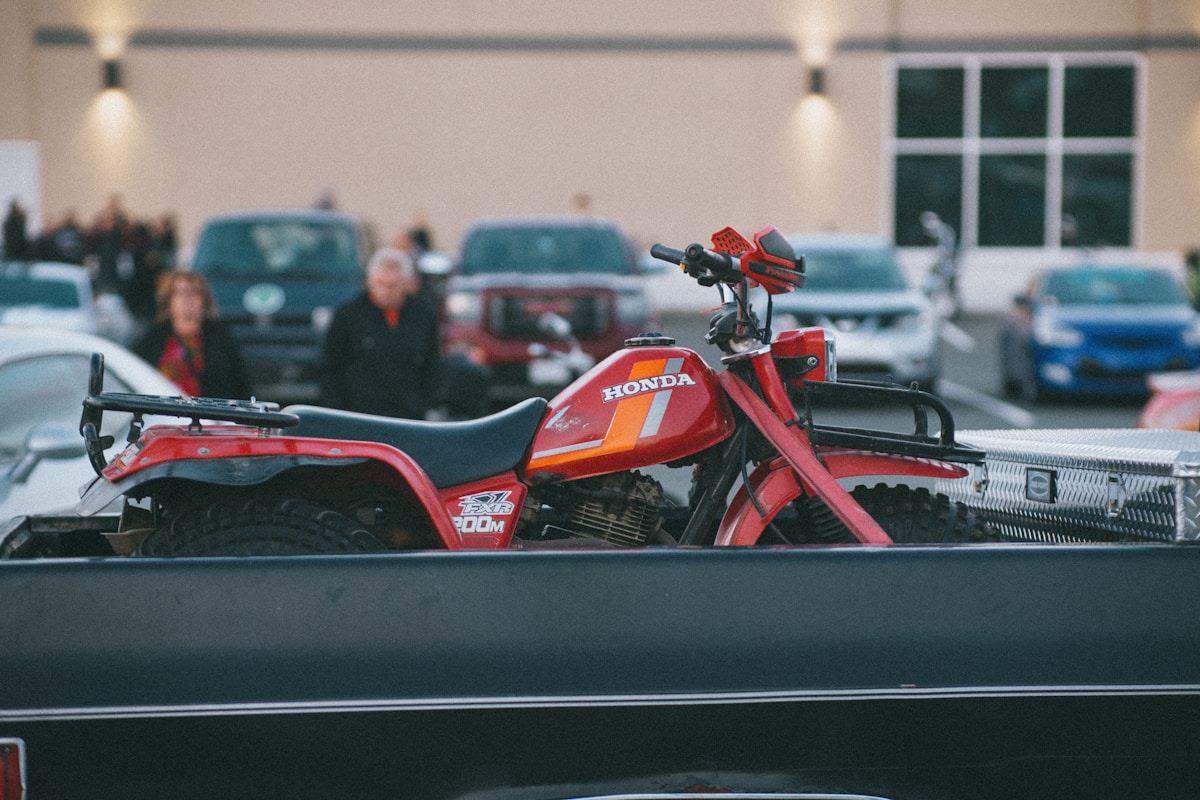 Moto Honda rouge sur une remorque dans un garage.